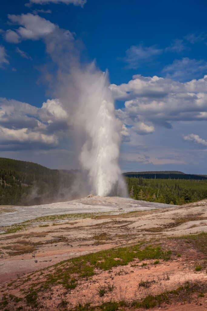 De geiser "Old Faithful" in Yellowstone National Park barst uit en spuit een torenhoge water- en stoomkolom hoog de lucht in