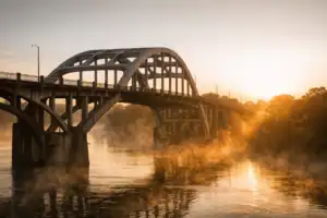 Edmund Pettus Bridge in Selma bij gouden uurlicht met ochtendnevel boven de Alabama River, plechtige sfeer